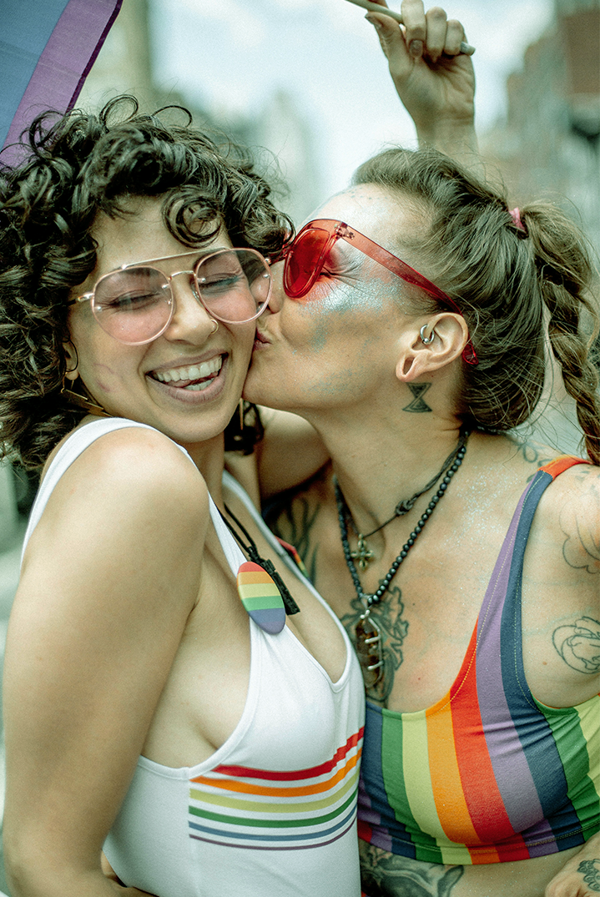 Two same-sex friends hugging and kissing.